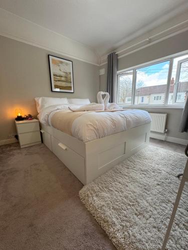 een slaapkamer met een wit bed en een raam bij Tayy’s Inn in Birmingham