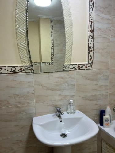 a bathroom with a white sink and a mirror at Achakar complexe payasage del costa in Jbila