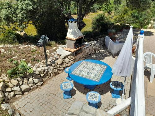 ein blauer Tisch und ein paar Stühle und ein Brunnen in der Unterkunft Casa dos Amigos - NEW management in Estói