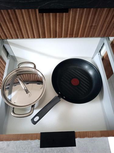 a pan and a whisk on top of a stove at AlfaHome ManuPark in Łódź