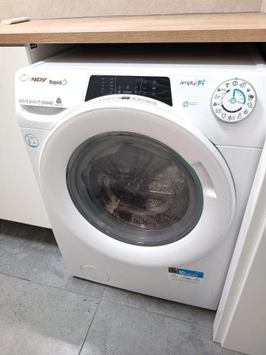 a white washing machine sitting under a counter at AlfaHome ManuPark in Łódź