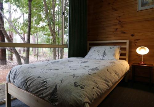 En eller flere senge i et værelse på Beedelup House Cottages