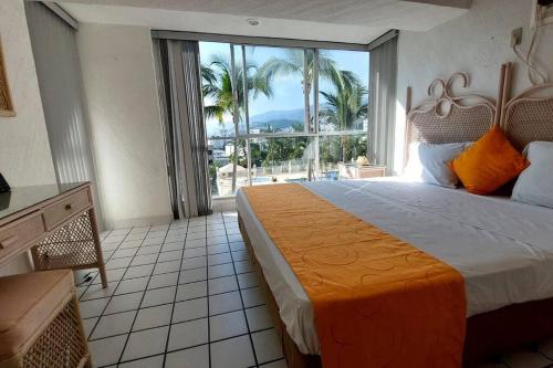 1 dormitorio con cama grande y ventana grande en Condominio en zona turística en Acapulco