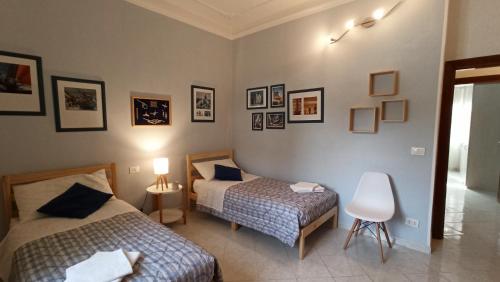 - une chambre avec 2 lits et une chaise dans l'établissement SeaGarden Apartment, à Livourne