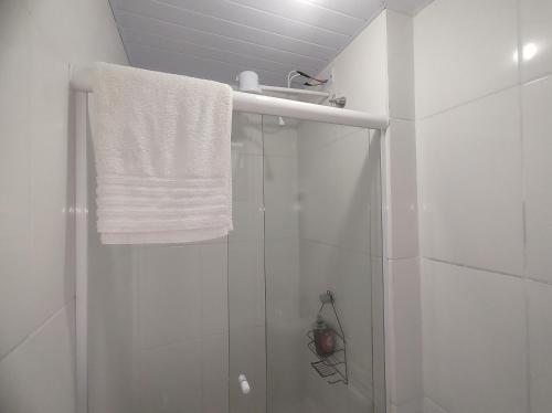 y baño con ducha y toalla blanca. en Apartamento Studio PNG novo e confortável en Paranaguá