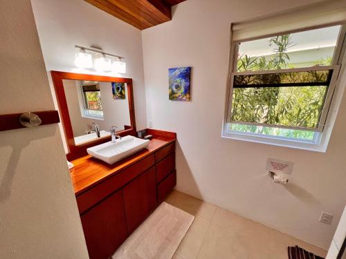 a bathroom with a sink and a mirror and a window at VeLento Partial Ocean View #6 in Caye Caulker