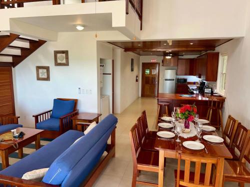 a dining room with a table and a blue couch at VeLento Partial Ocean View Penthouse #7 in Caye Caulker