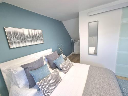 a bedroom with blue walls and a white bed with pillows at Spacious Town House - Coventry City Centre, Free Parking, Sleeps 6, High-Speed WiFi, En-suite, Great Location, A45, A46, JLR, NEC, Airport, Warwick & Stratford Upon Avon - Fernwood Stays - Your home away from home! in Coventry