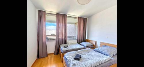 a bedroom with two beds and a large window at Stunning 1-Bed Apartment in Neuss in Neuss