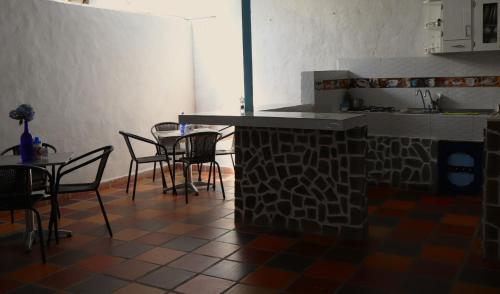 a kitchen with a counter and chairs and a table at Vista Farallones Hostel in Jardin