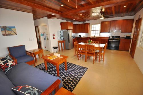 ein Wohnzimmer und eine Küche mit einer Couch und einem Tisch in der Unterkunft VeLento Oceanfront #2 in Caye Caulker