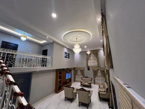 a room with a staircase with chairs and a table at EuChris Homes in Kumasi