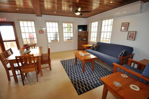 a living room with a blue couch and a table at VeLento Oceanfront #4 in Caye Caulker