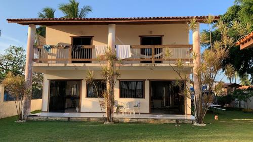 Cette grande maison dispose d'un balcon et de palmiers. dans l'établissement Casa a Beira mar na Barra do Serinhaem Ituberá - Bahia - Brasil, à Sirinhaém