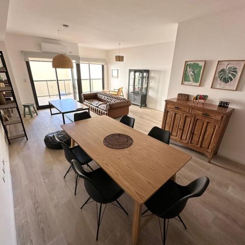 sala de estar con mesa de madera y sillas en Virasoro Apartment en Buenos Aires