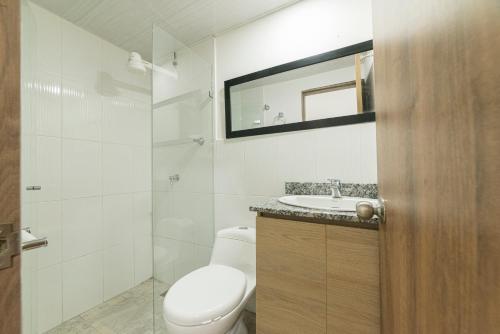 a bathroom with a toilet and a sink and a mirror at Loft Urbano en Medellín Pet Friendly 105 in Medellín