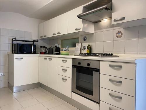 a kitchen with white cabinets and a stove top oven at Dolce vita Assisi flat two bedrooms two bathrooms in Assisi