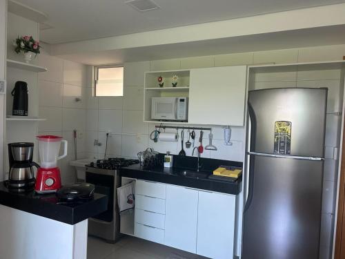 a kitchen with a stainless steel refrigerator and white cabinets at Excelente FLAT 2 QTS BESSA - FLAT ALTÂNTICO NORTE in João Pessoa