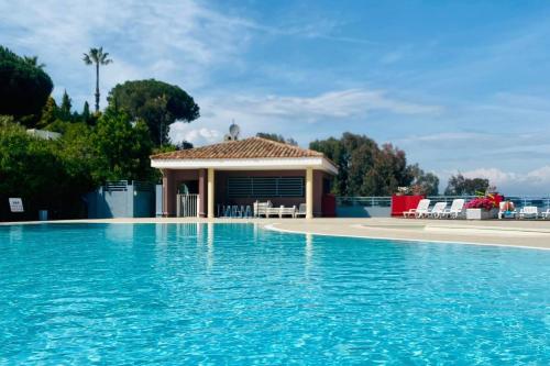a villa with a swimming pool and a house at Sweet Apartment in Mandelieu - Pool & tennis court in Mandelieu-la-Napoule
