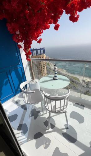 a table and chairs on a balcony with the ocean at برج داماك الكورنيش الجناح اليوناني Damac jeddah Tower in Jeddah