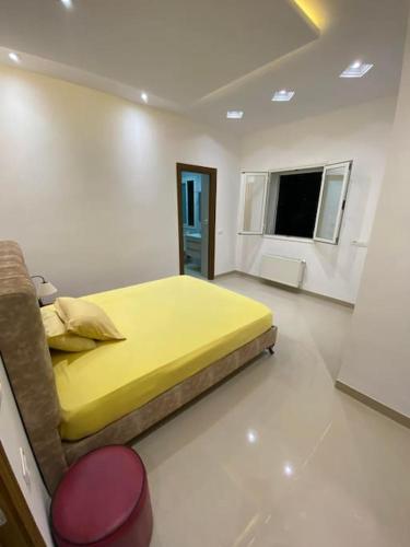 a bedroom with a yellow bed and a window at Nouvel appartement jamais habité in Hammamet Nord