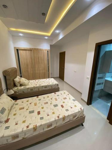 um quarto com duas camas num quarto com uma janela em Nouvel appartement jamais habité em Hammamet Nord
