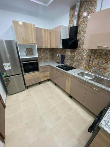 uma cozinha com um frigorífico e um lavatório em Nouvel appartement jamais habité em Hammamet Nord