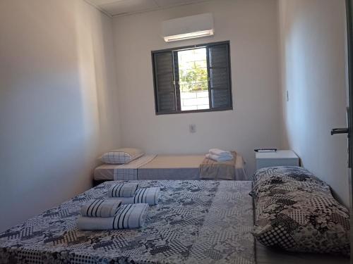 niewielka sypialnia z 2 łóżkami i oknem w obiekcie New hotel w mieście Alegrete