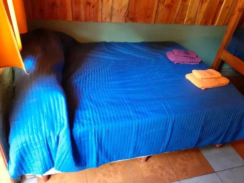 a blue bed with two towels on top of it at Camping El Bosque in El Hoyo