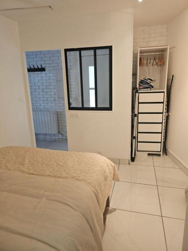 - une chambre avec un lit et une fenêtre dans l'établissement KIFKIF, à Saint-Germain-lès-Arpajon