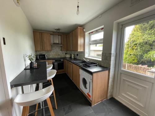 a kitchen with a stove top oven next to a window at 2BR 15 min to BHX Airport 5 min to Heartlands in Birmingham