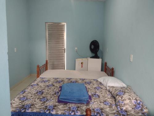 a bedroom with a bed with a blanket on it at SITIO CAMINHO DAS PEDRAS - Suítes e Chalés in São Thomé das Letras