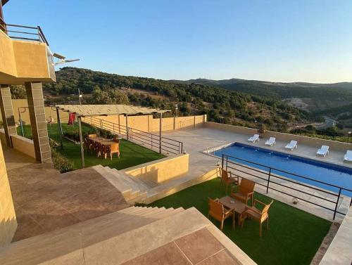 een uitzicht op een huis met een zwembad bij Mountain farm in Ajloun