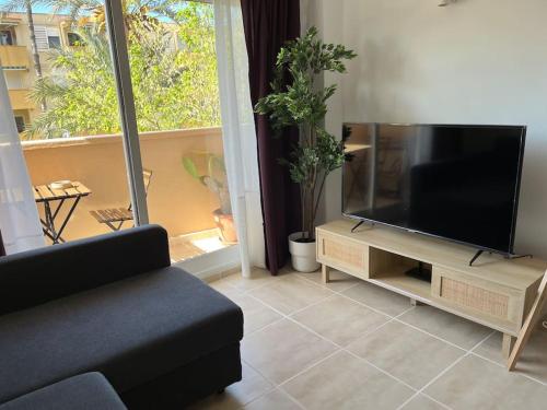 a living room with a couch and a flat screen tv at Endeless Summer - Playa Arenal in Platja de l'Arenal