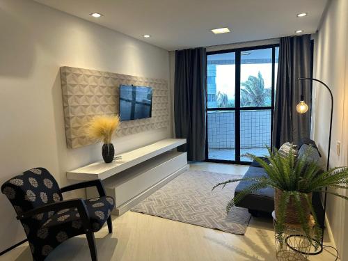 a living room with a couch and a tv on a wall at (216) Clean Beach - Near The Beach in Pimenta
