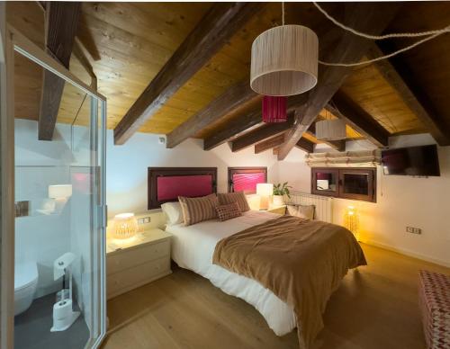 a bedroom with a large bed and a glass shower at Hotel Rural Flor de Almendro in Loarre