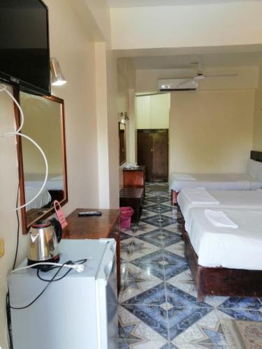 a hotel room with two beds and a tv at Rezeiky Hotel & Camp in Luxor