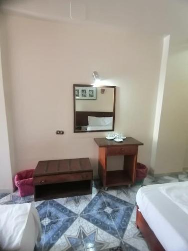 a room with a table and a mirror and a bed at Rezeiky Hotel & Camp in Luxor