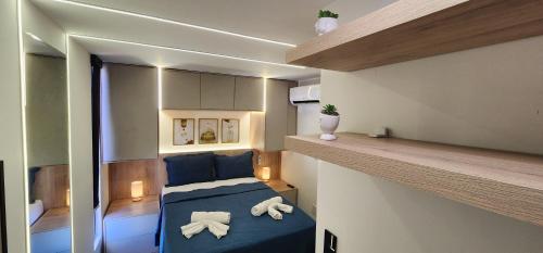 a small apartment with a blue bed in a room at Hamptons João Pessoal in João Pessoa