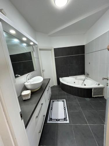 een badkamer met een bad, een wastafel en een bad bij דירה על הים in Netanya