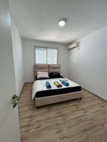 een slaapkamer met een bed en een houten vloer bij דירה על הים in Netanya