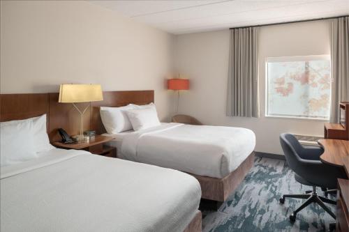 a hotel room with two beds and a desk at Fairfield Inn Boston Tewksbury/Andover in Tewksbury