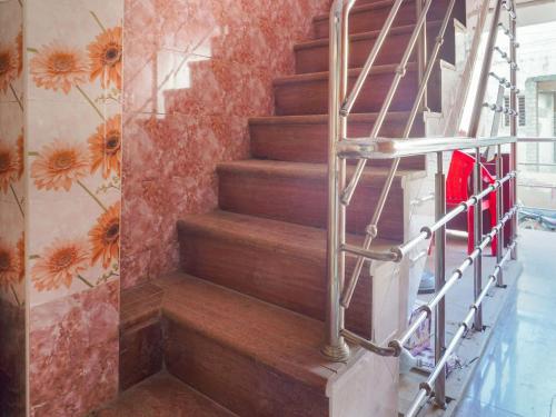 a staircase in a building with a flower mural at OYO Flagship Ks Elite in Madurai