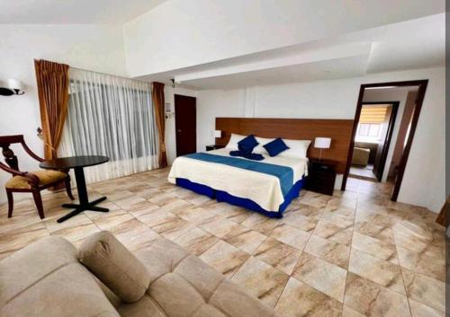 1 dormitorio con cama, mesa y sofá en Casa Darjona, en Puerto Baquerizo Moreno