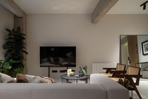 a living room with a couch and a tv at Arivare Cormelana in A Coruña