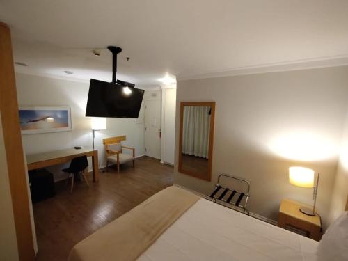 um quarto com uma cama, uma secretária e uma televisão em H1503 Suíte Luxo Flat Hotel Aeroporto Congonhas em São Paulo