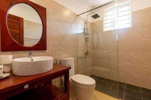 a bathroom with a sink and a toilet and a mirror at Elegant Escape Residence in Siem Reap