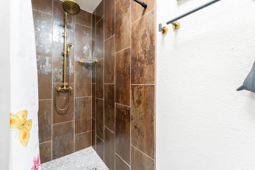 a bathroom with a shower with brown tiles at Blue Sparrow's Nest in Green Mountain Falls