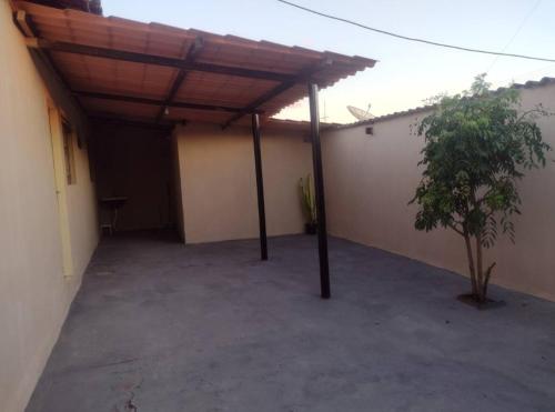 a garage with a wooden roof and a tree at Casa em Uberaba com garagem in Uberaba