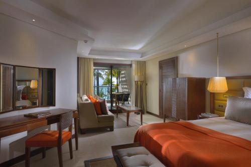 Pokój hotelowy z łóżkiem i biurkiem w obiekcie Royal Palm Beachcomber Luxury w mieście Grand Baie